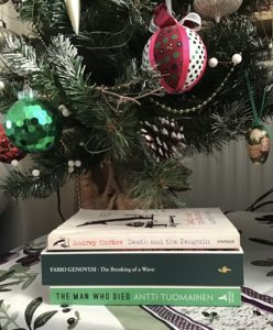 A stack of three books under a Christmas tree, all are comedy titles